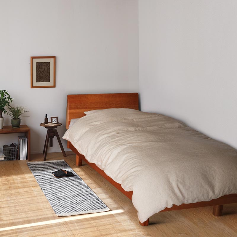 自然素材の寝具と無垢材のベッドフレーム
